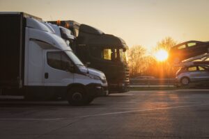 Open car transporters hauling vehicles at sunset