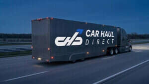 Car Haul Direct branded enclosed auto transport truck on interstate at dusk