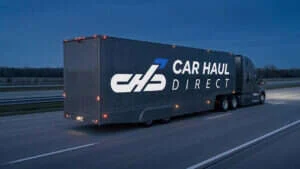 Car Haul Direct branded enclosed auto transport truck on interstate at dusk